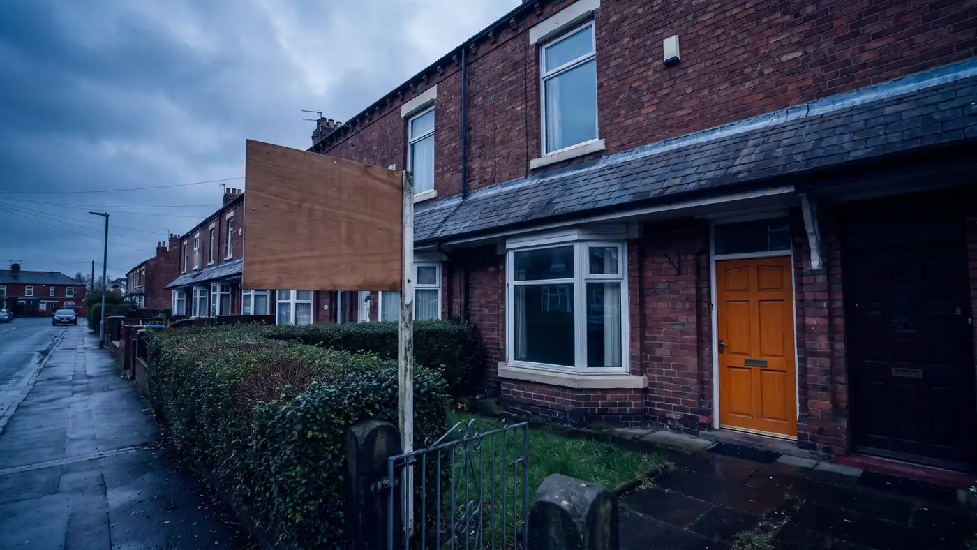 Estate agent board outside a UK bay fronted terraced house